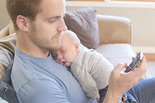 Father with baby texting